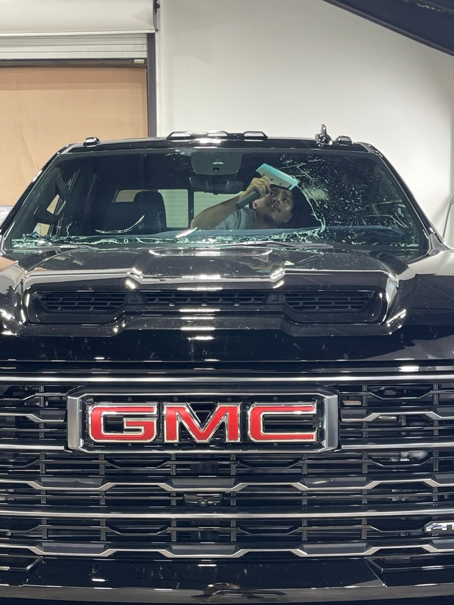Professional window tinting action shot — technician applying tint film by Auto Trim Design