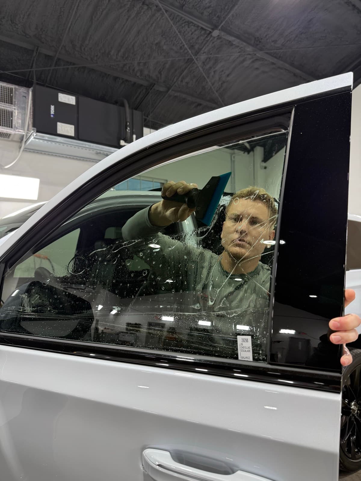 ATD Suncoast technician using squeegee to smooth window tint film