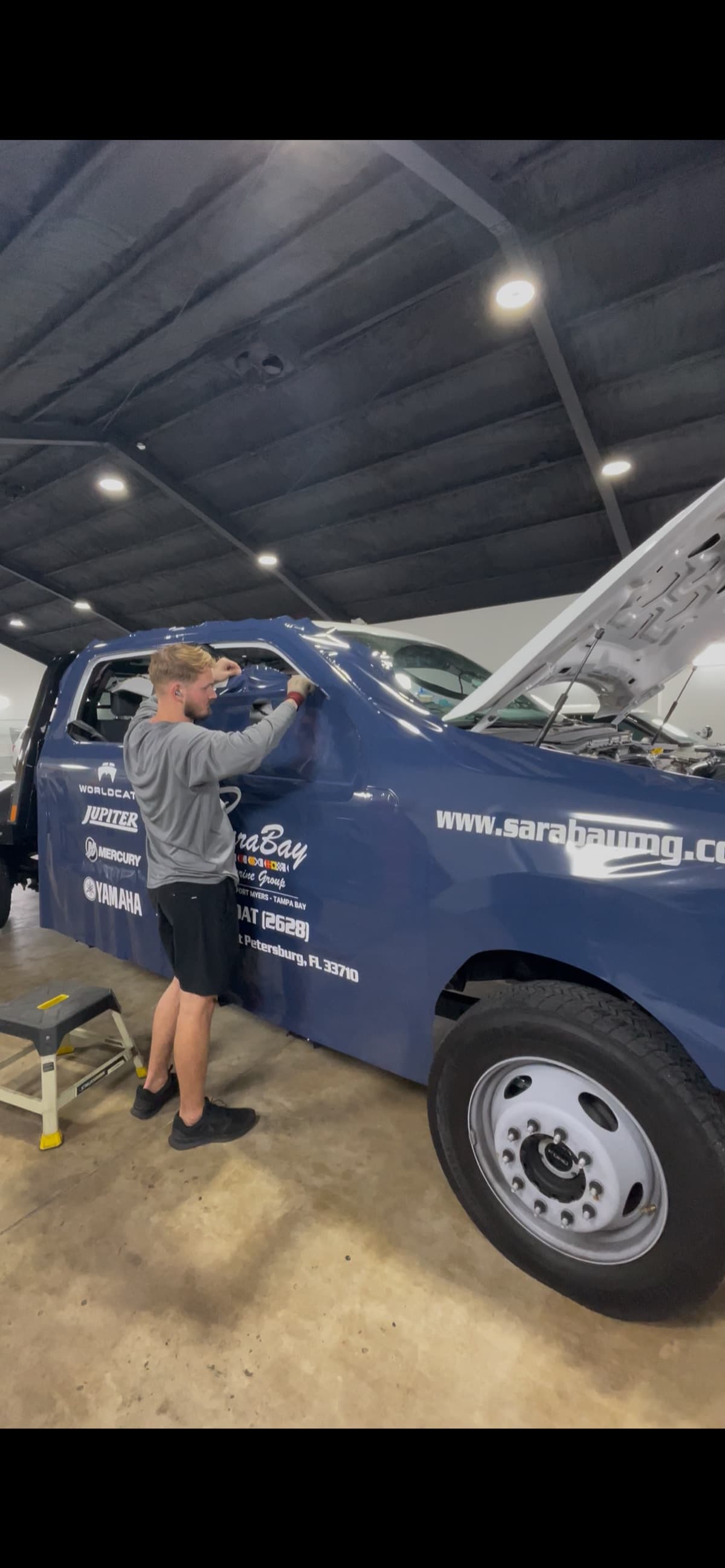 ATD technician wrapping commercial truck in shop — action shot